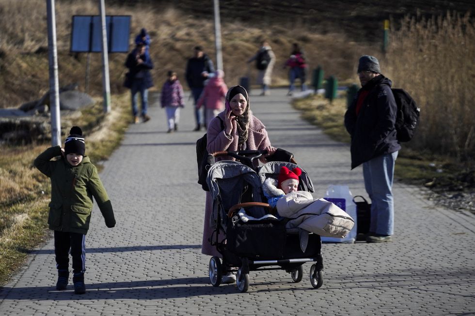 A family arrives at the Polish border crossing after fleeing violence in Ukraine, in Medyka, Poland, February 24, 2022. REUTERS/Bryan Woolston