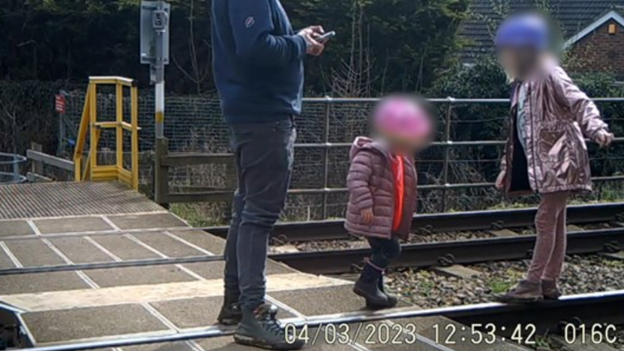 ​A father and his children playing on the tracks