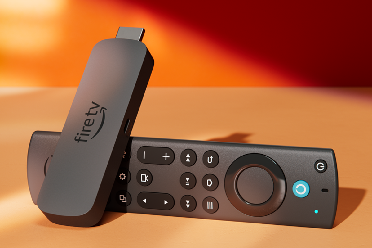 a fire tv stick pictured lying on its side in warm sunlight 