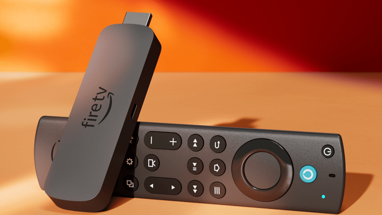 a fire tv stick pictured lying on its side in warm sunlight