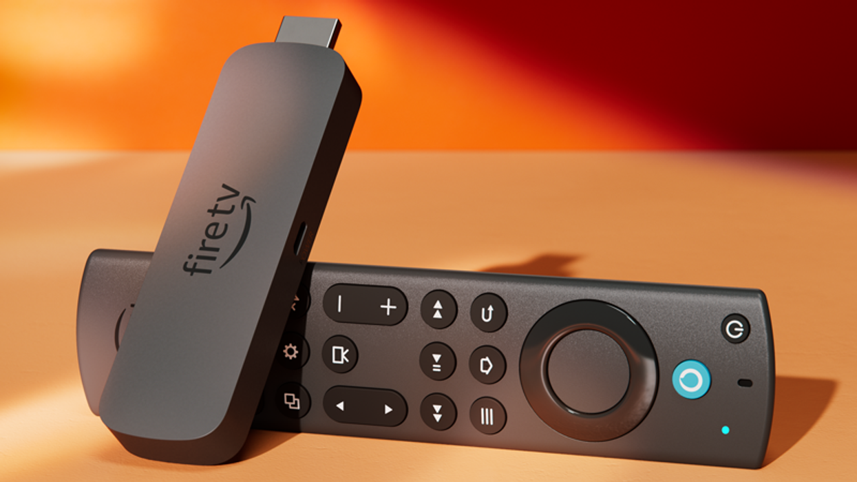 a fire tv stick pictured lying on its side in warm sunlight