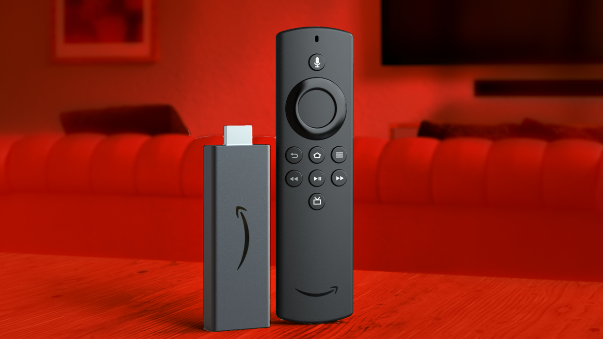 a fire tv stick pictured on a table with a living room seen in the background