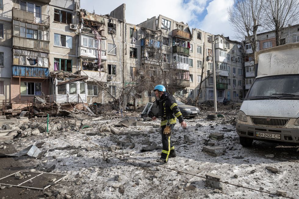 A firefighter walks at a car park near an apartment block that was heavily damaged by a missile strike, amid Russia's attack on Ukraine, in Pokrovsk, Donetsk region, Ukraine, February 15, 2023. REUTERS/Marko Djurica