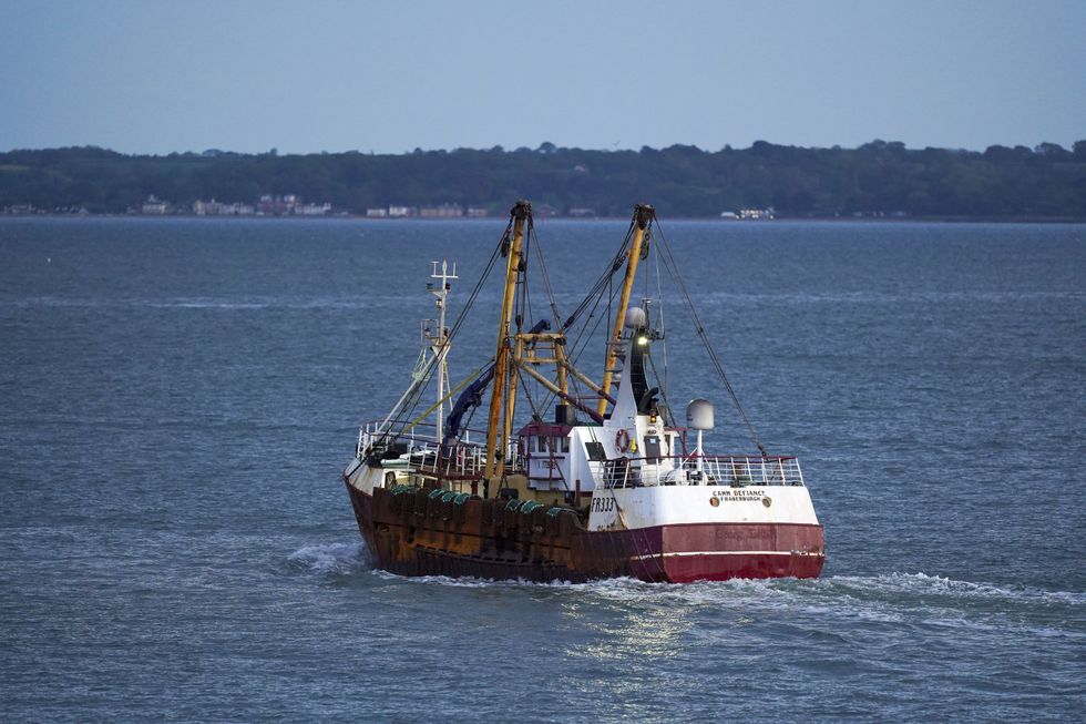 A fishing trawler leaves the harbour in Portsmouth, Hampshire.