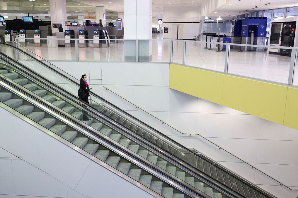 A flight crew member stands on an escalator in the international terminal at Sydney Airport, as countries react to the new coronavirus Omicron variant amid the coronavirus disease (COVID-19) pandemic, in Sydney.