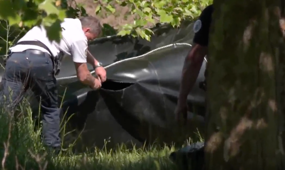 A French officer slashes an inflatable boat