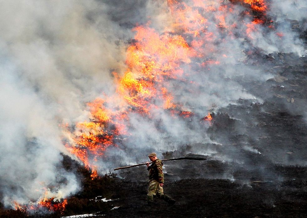 A gamekeeper beats back the flames as he burns heather on the Invercauld Estate near Braemar.
