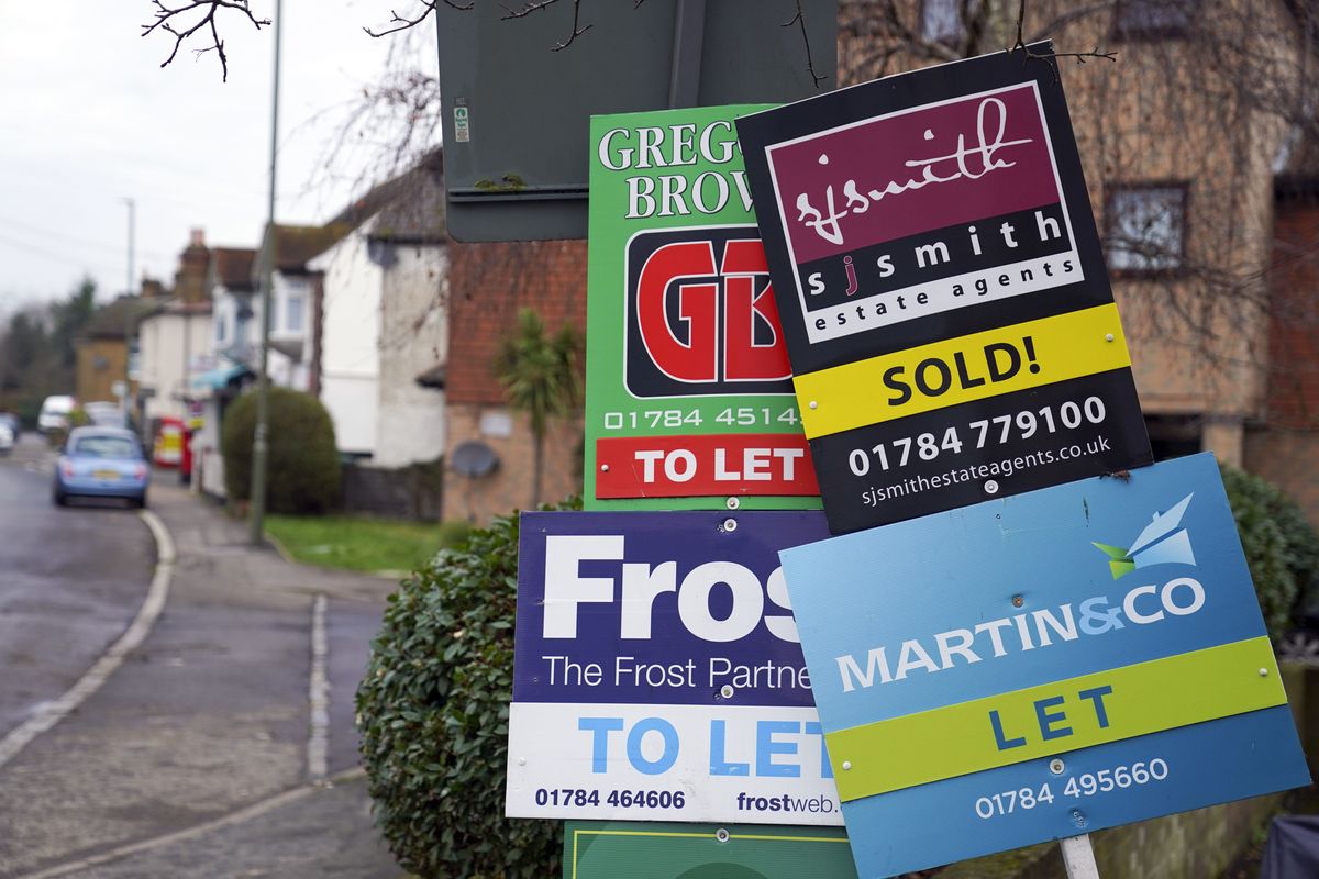 A general view of estate agent boards outside a property in Staines-upon-Thames in Surrey