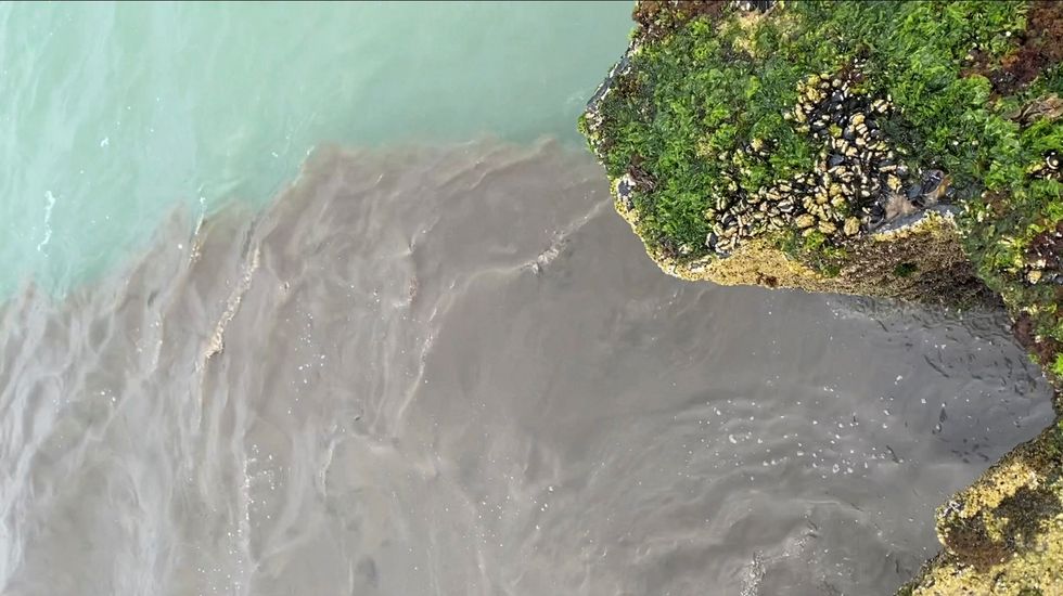 A general view of sewage being discharged into the sea, in Seaford, East Sussex, Britain, August 16, 2022 in this screen grab obtained from a social media video. Twitter @craddock1970/via REUTERS THIS IMAGE HAS BEEN SUPPLIED BY A THIRD PARTY. MANDATORY CREDIT. NO RESALES. NO ARCHIVES.