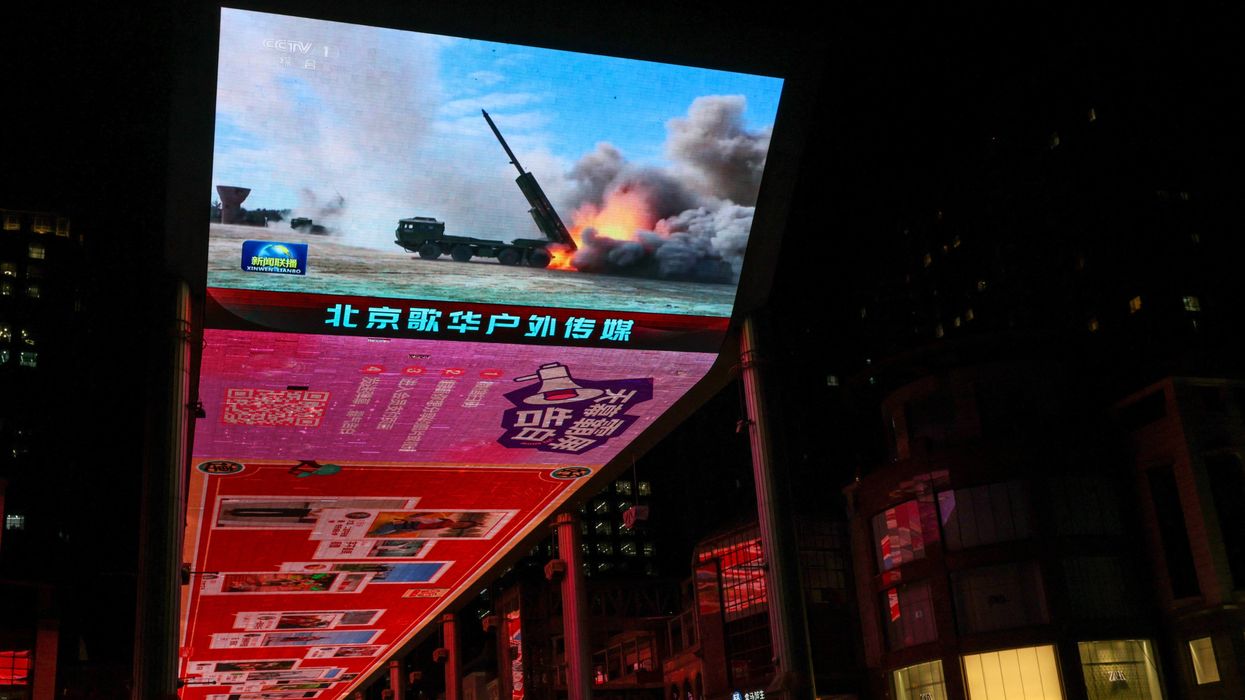 A giant screen shows a news report on China's "Justice Mission 2025" military drills around Taiwan, in Beijing