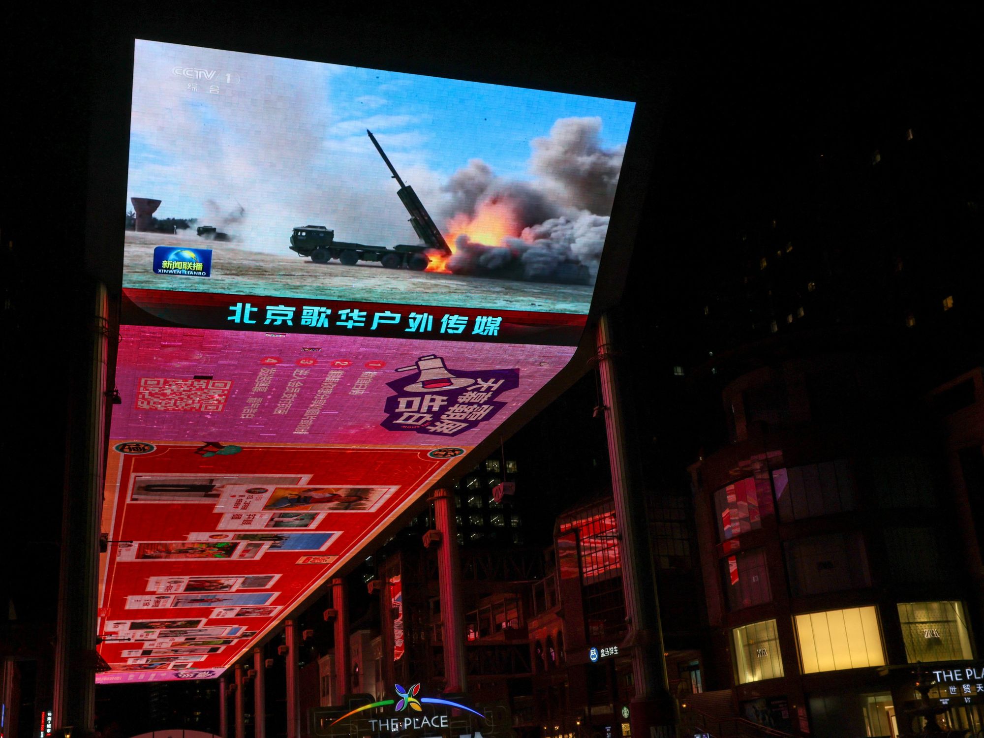 A giant screen shows a news report on China's "Justice Mission 2025" military drills around Taiwan, in Beijing