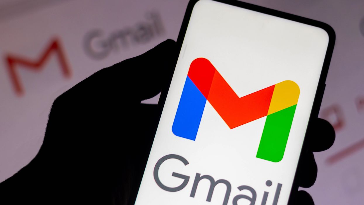 a gmail logo appears on a smartphone screen with a screenshot of an inbox in the background
