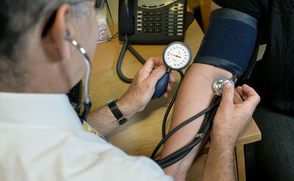A GP checking a patient's blood pressure.
