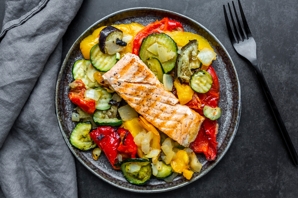 A grey plate with salmon, legumes and peppers