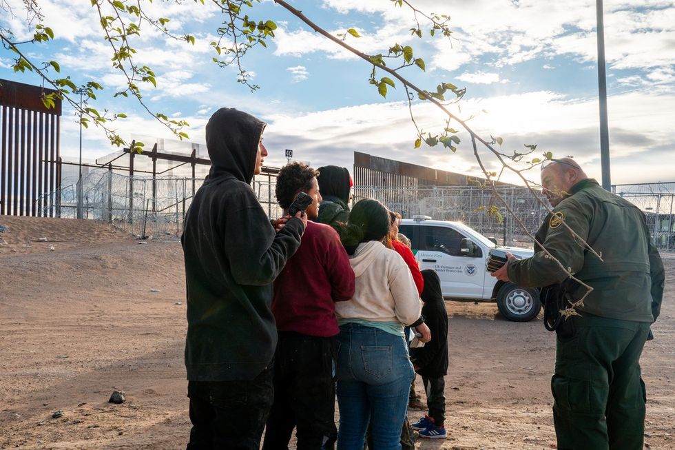 A group of migrants wait to be processed after crossing the Rio Grande river on April