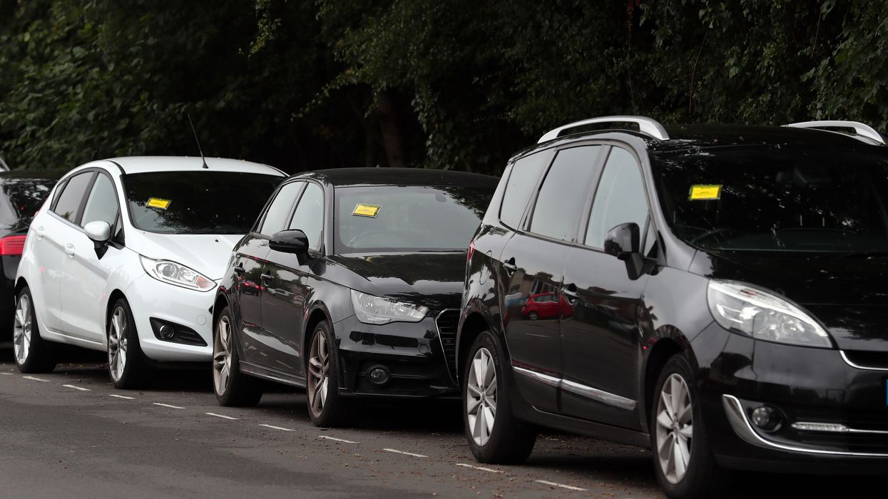 A group of parked cars with parking fines.