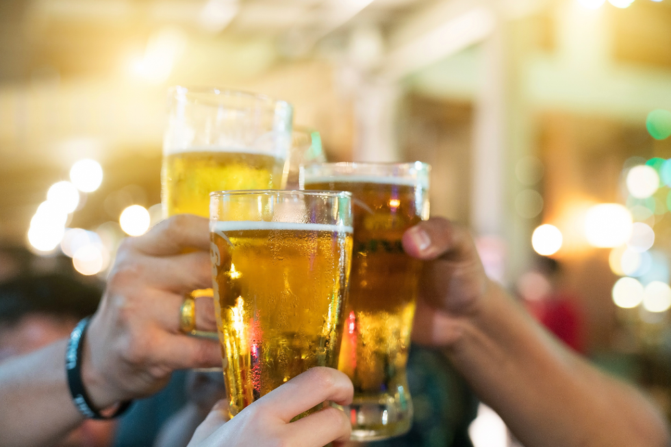 A group of people holding up their beer