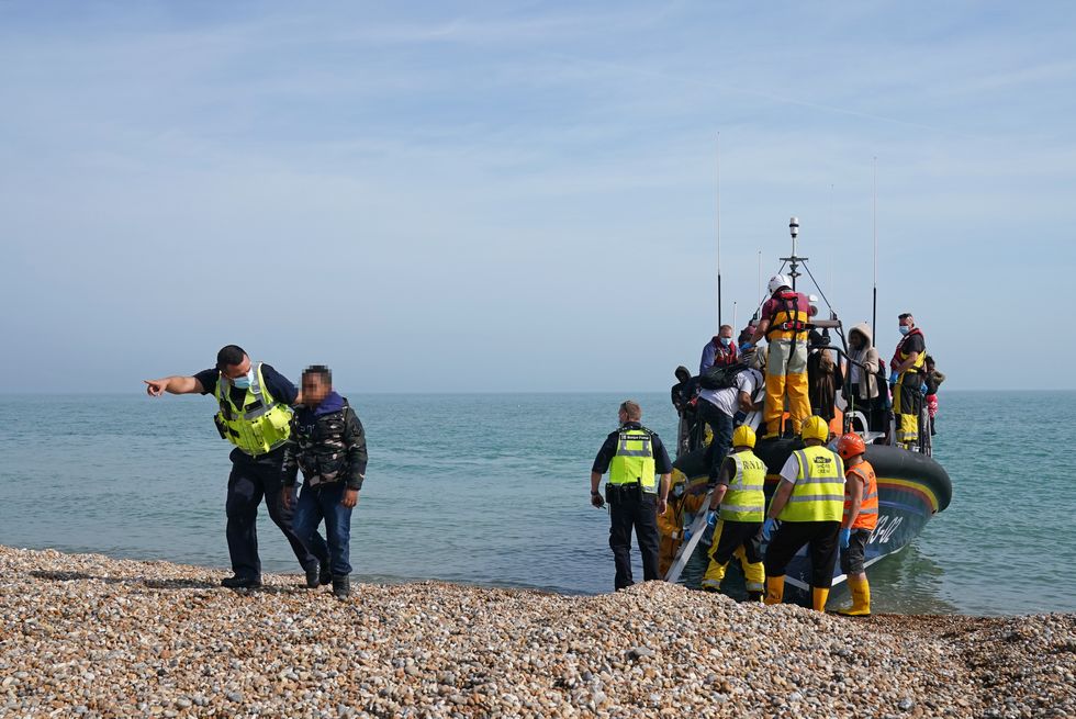 A group of people thought to be migrants are brought ashore from the local lifeboat at Dungeness in Kent.