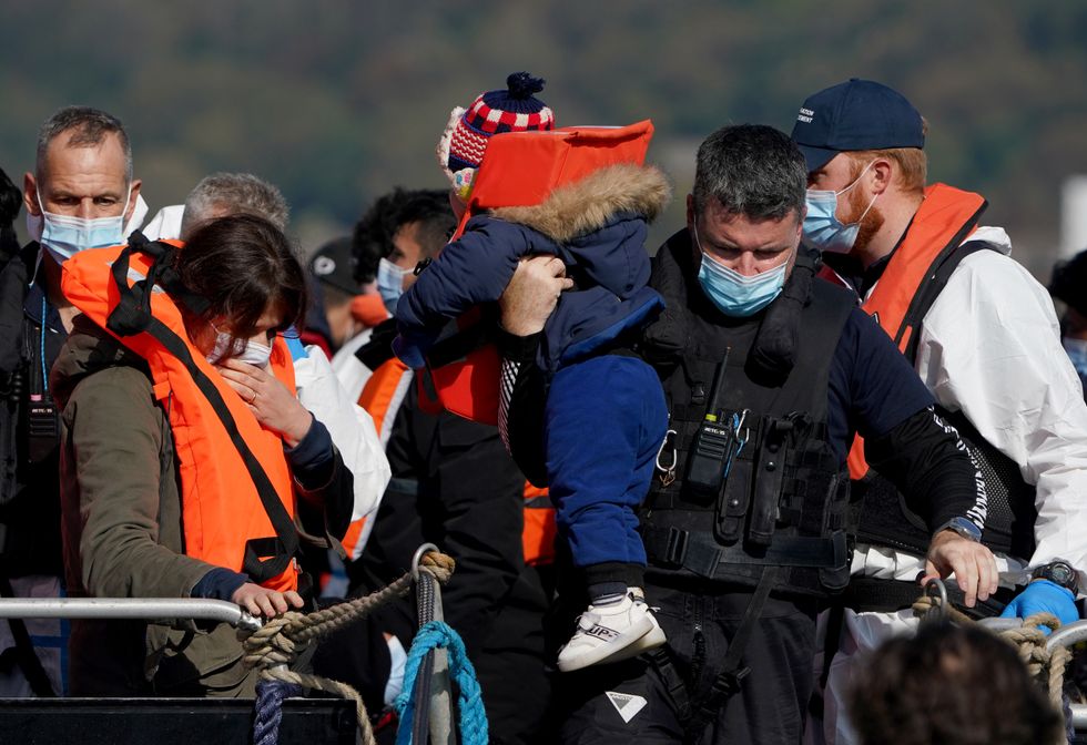 A group of people thought to be migrants are brought in to Dover, Kent, by Border Force officers, following a small boat incident in the Channel. Picture date: Friday October 8, 2021.
