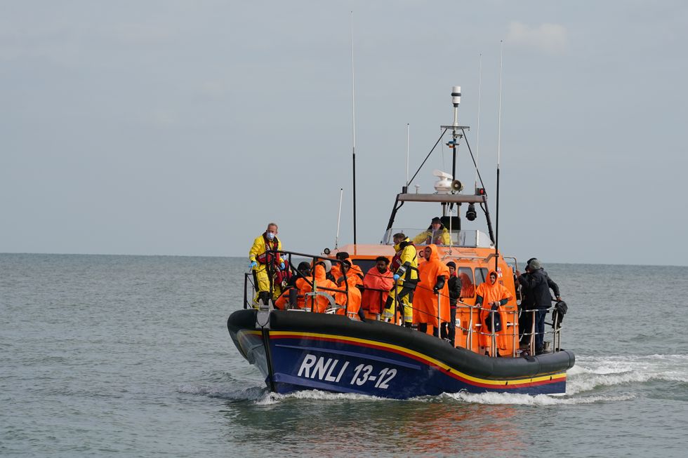 A group of people thought to be migrants are brought in to Dungeness beach by the Dungeness lifeboat following a small boat incident in the Channel. Picture date: Wednesday October 12, 2022.