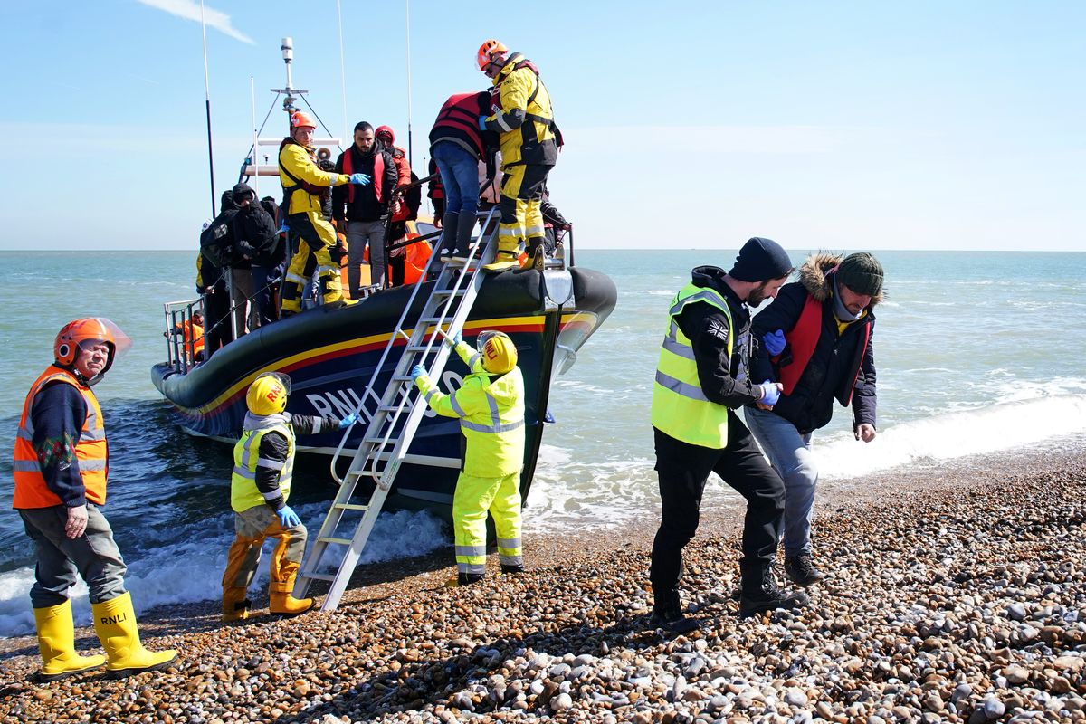 A group of people thought to be migrants arrive on the beach in Dungeness, Kent