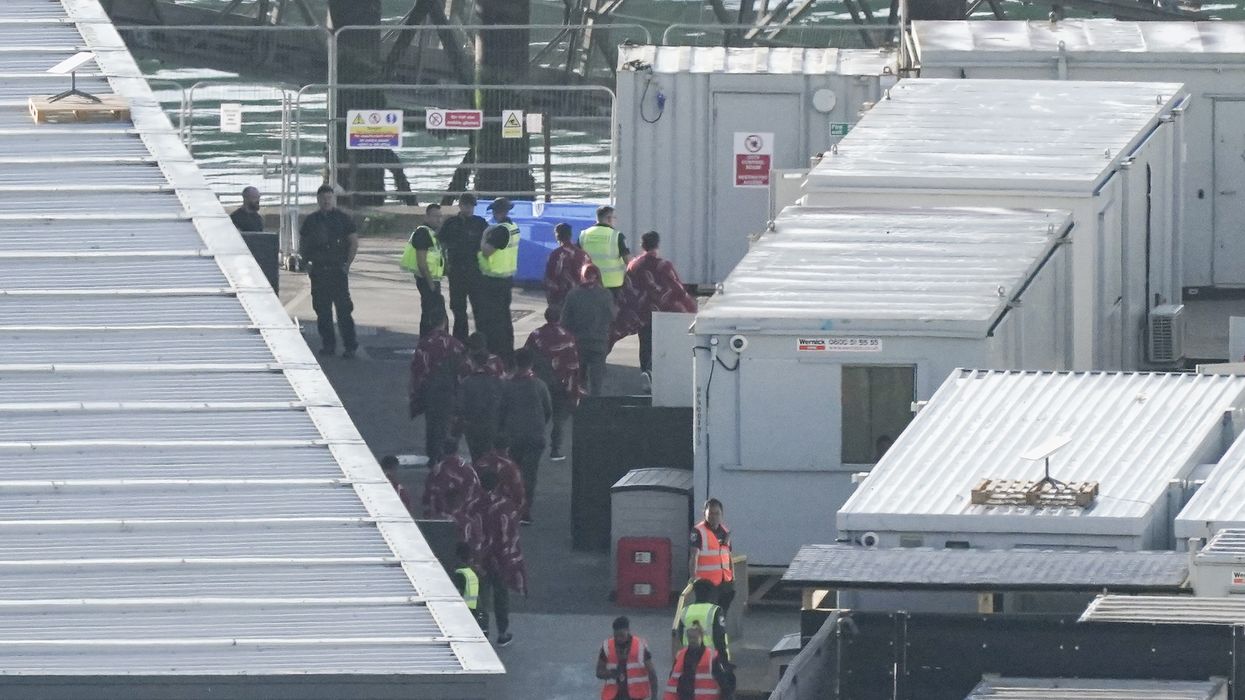 A group of people thought to be migrants board a coach at the Border Force compound in Dover