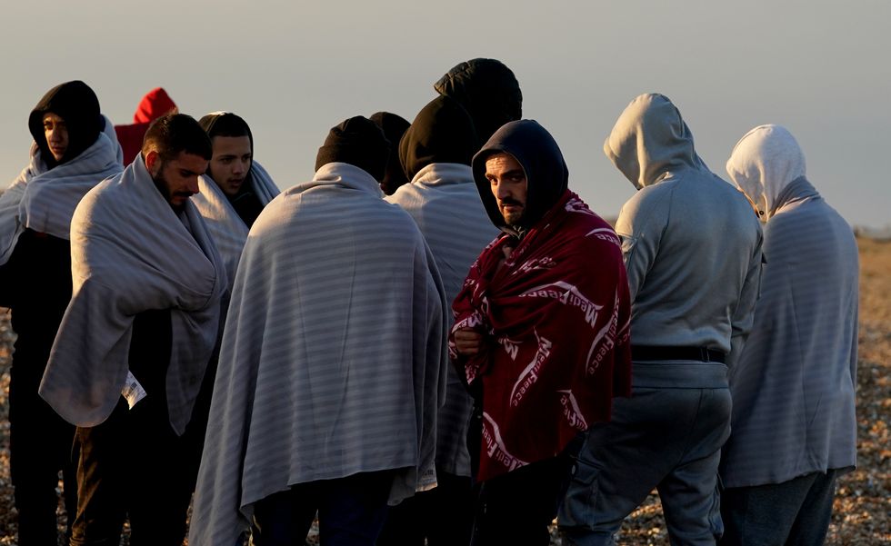 A group of people thought to be migrants walk up the beach in Dungeness, Kent, after being rescued in the Channel by the RNLI following following a small boat incident. Picture date: Wednesday September 21, 2022.