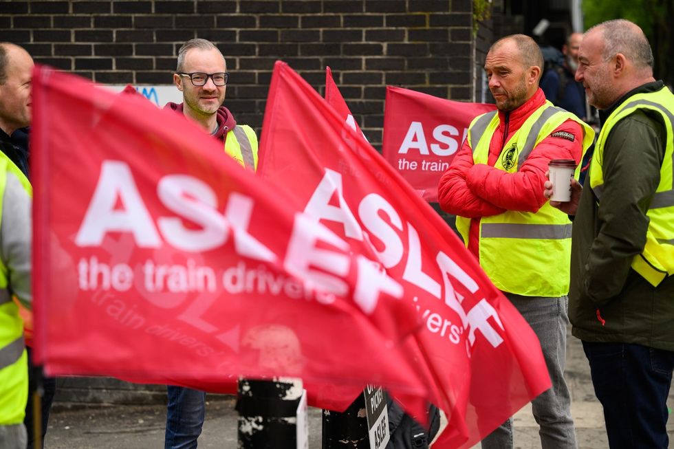 A group of rail workers stand on a picket line outside Euston rail station