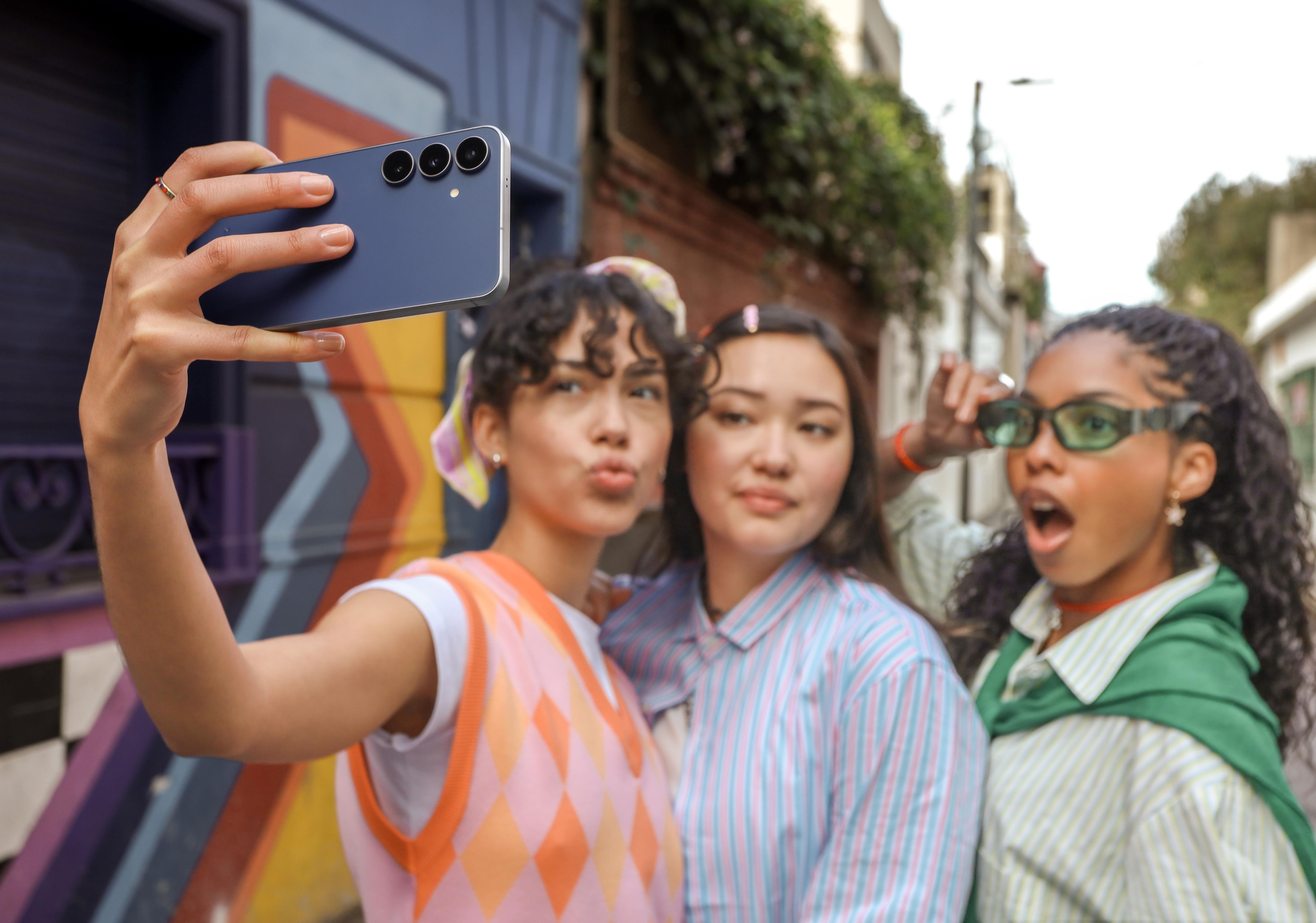 a group of women take pictures with the galaxy s25 fe
