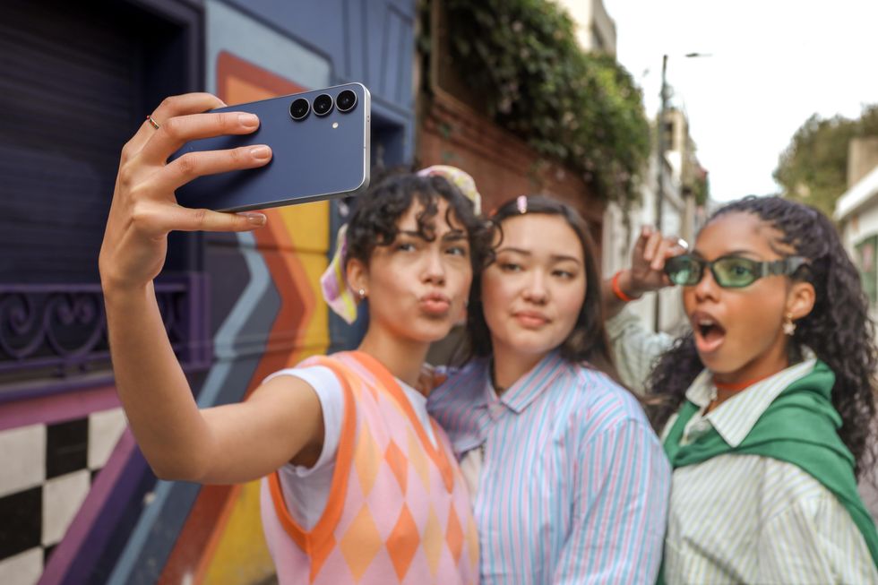 a group of women take pictures with the galaxy s25 fe