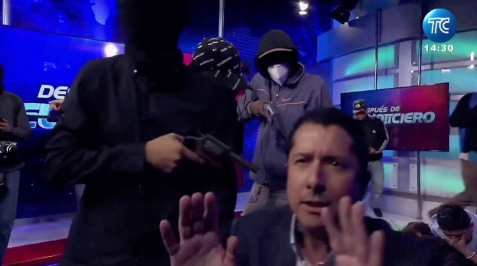 A gunman pointing a gun at a tv presenter