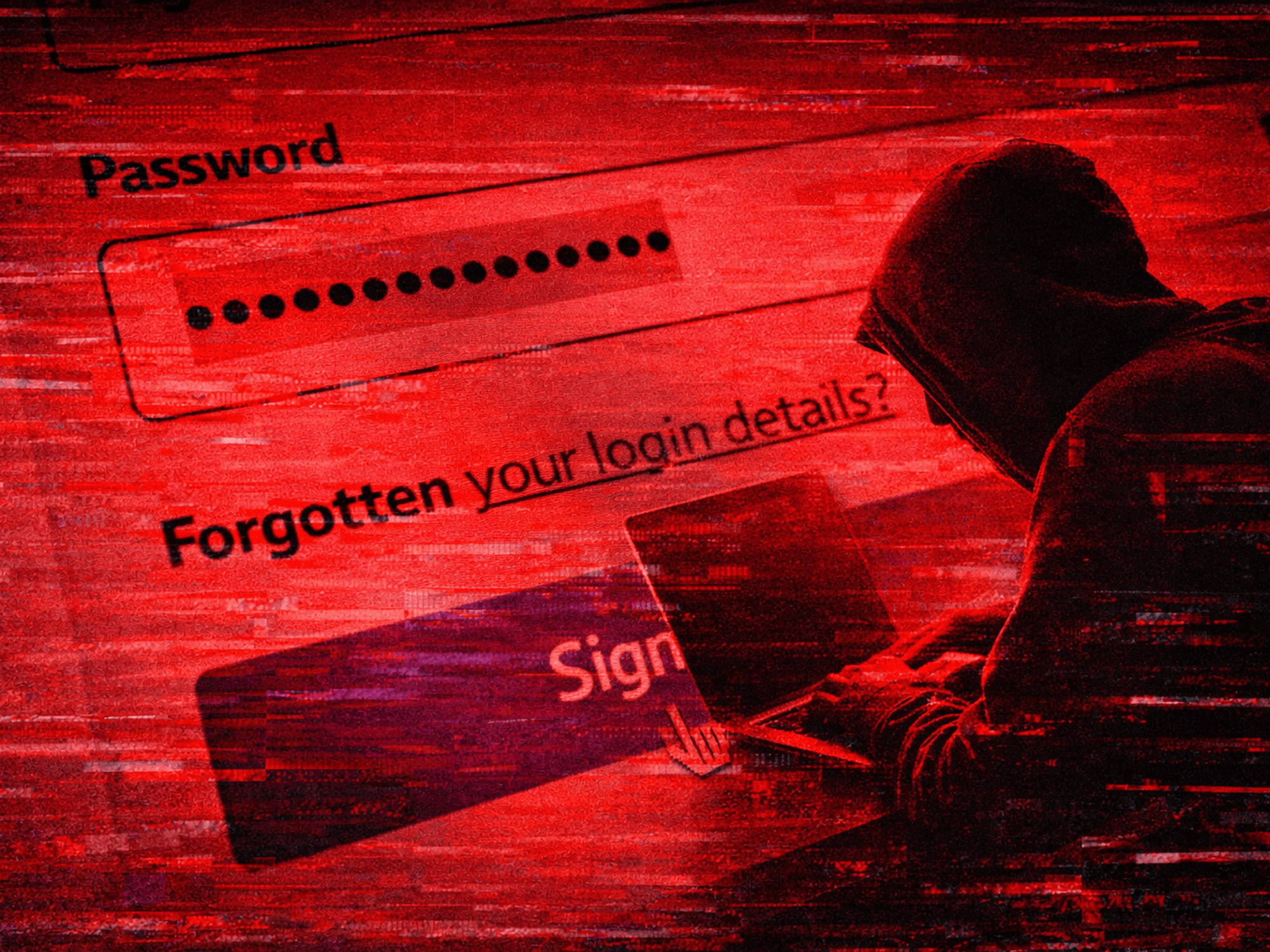 a hacker sits hunched over a laptop with a password login screen shown in the background