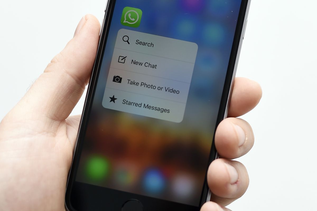 a hand holding a smartphone with the whatsapp icon 