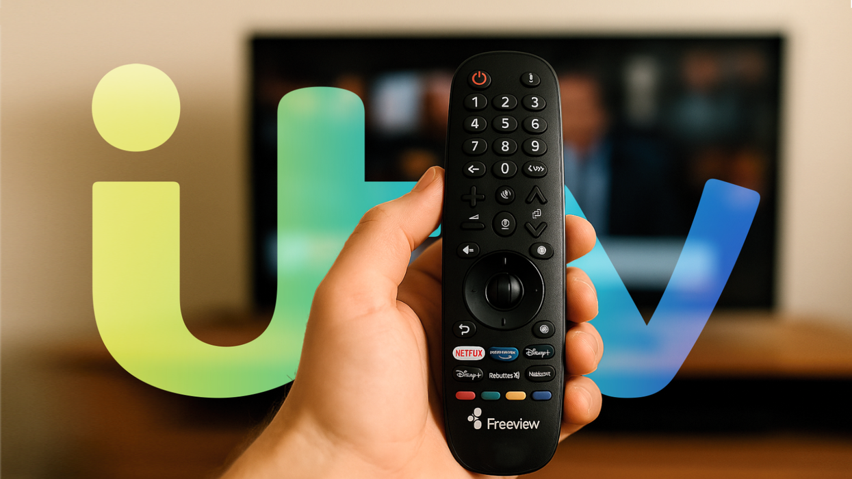 a hand holds a freeview remote control with the itv logo in the background