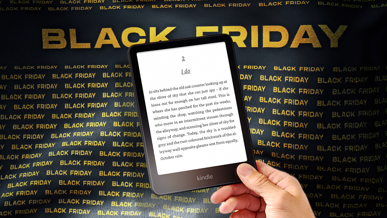 a hand holds a kindle paperwhite on a black friday banner