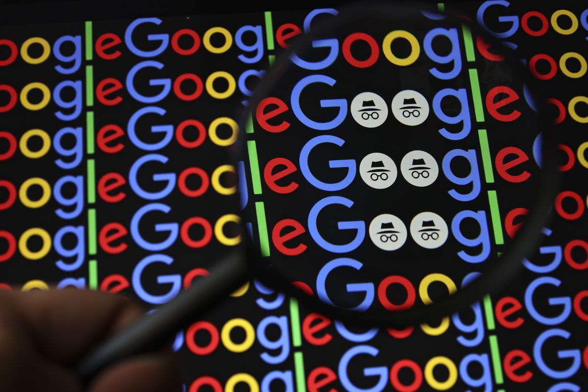 a hand holds a magnifying glass over google logo to reveal the incognito mode icon 