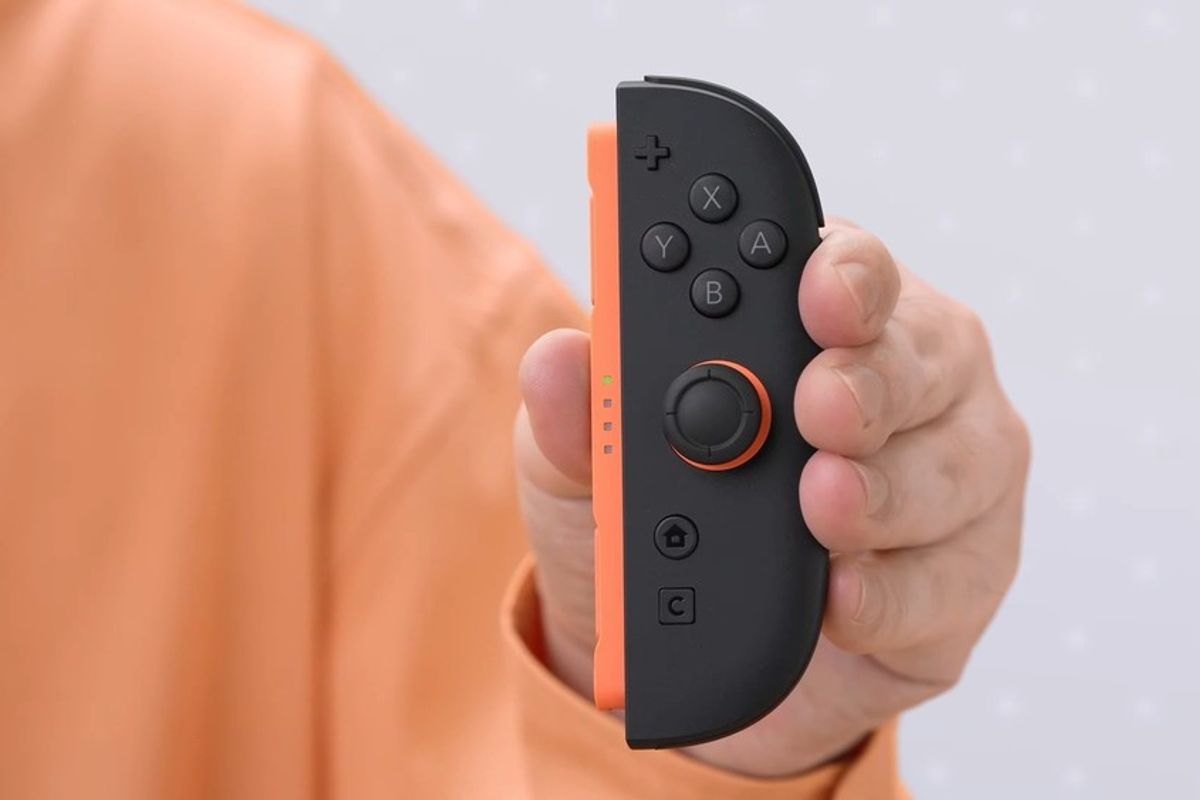 a hand holds switch 2 controller showing the C button