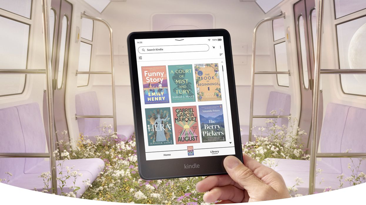 a hand holds the kindle colorsoft in a subway train