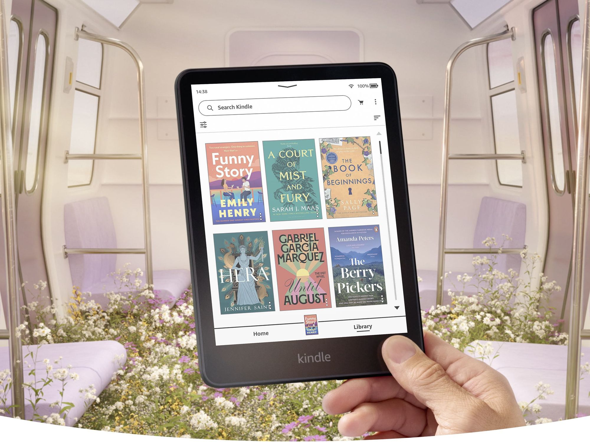 a hand holds the kindle colorsoft in a subway train