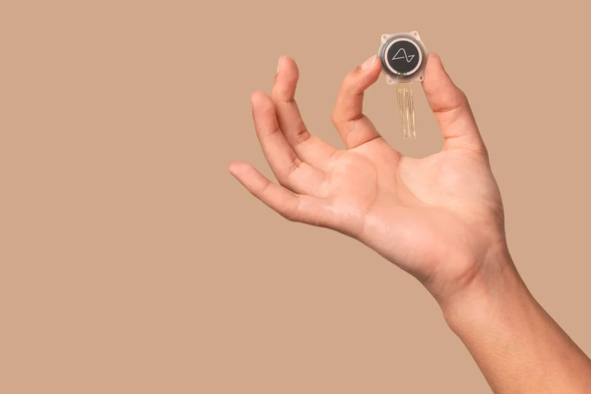 a hand holds the neuralink chip