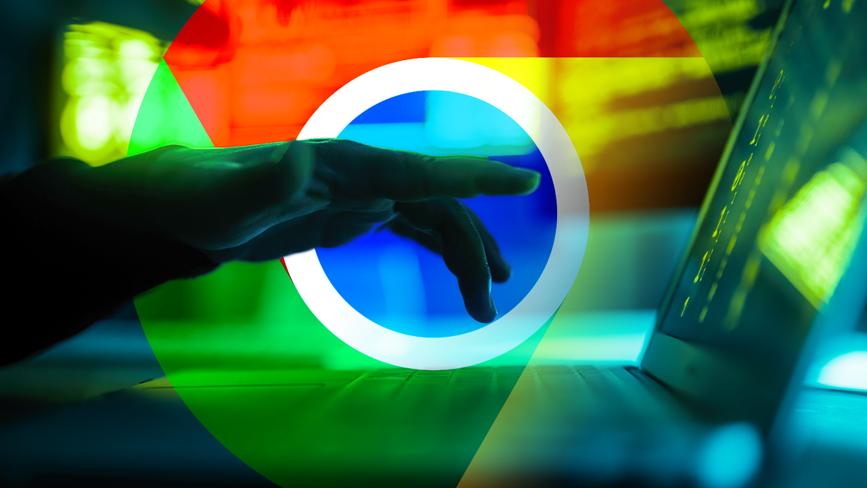 a hand hovers after typing on a laptop with the google chrome web browser logo in the background