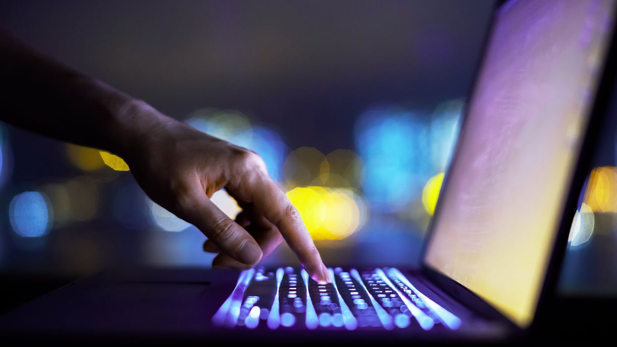 a hand presses a keyboard to type a letter on-screen