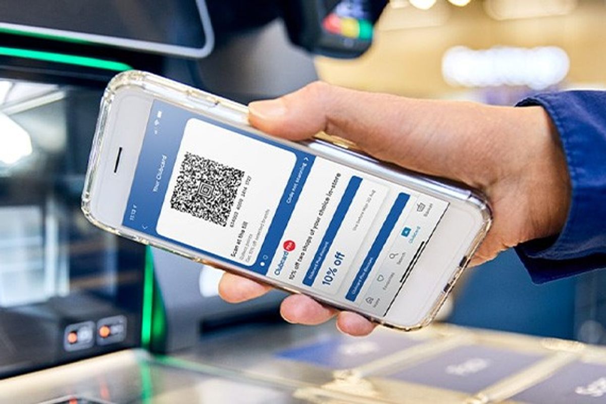 a hand scans the barcode built into the tesco clubcard app on an iphone