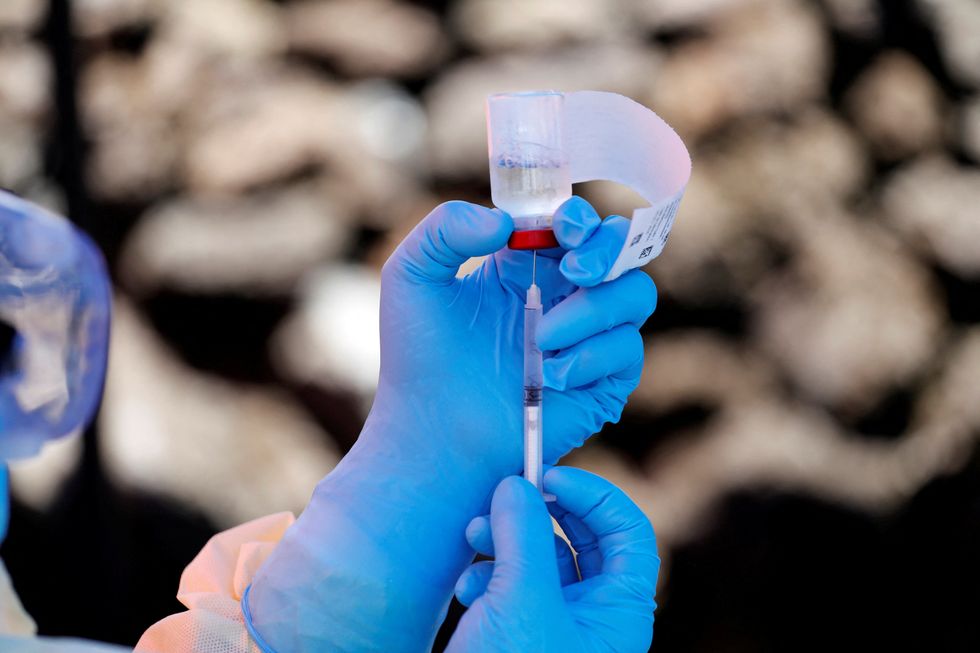A health worker filling a syringe with Ebola vaccine