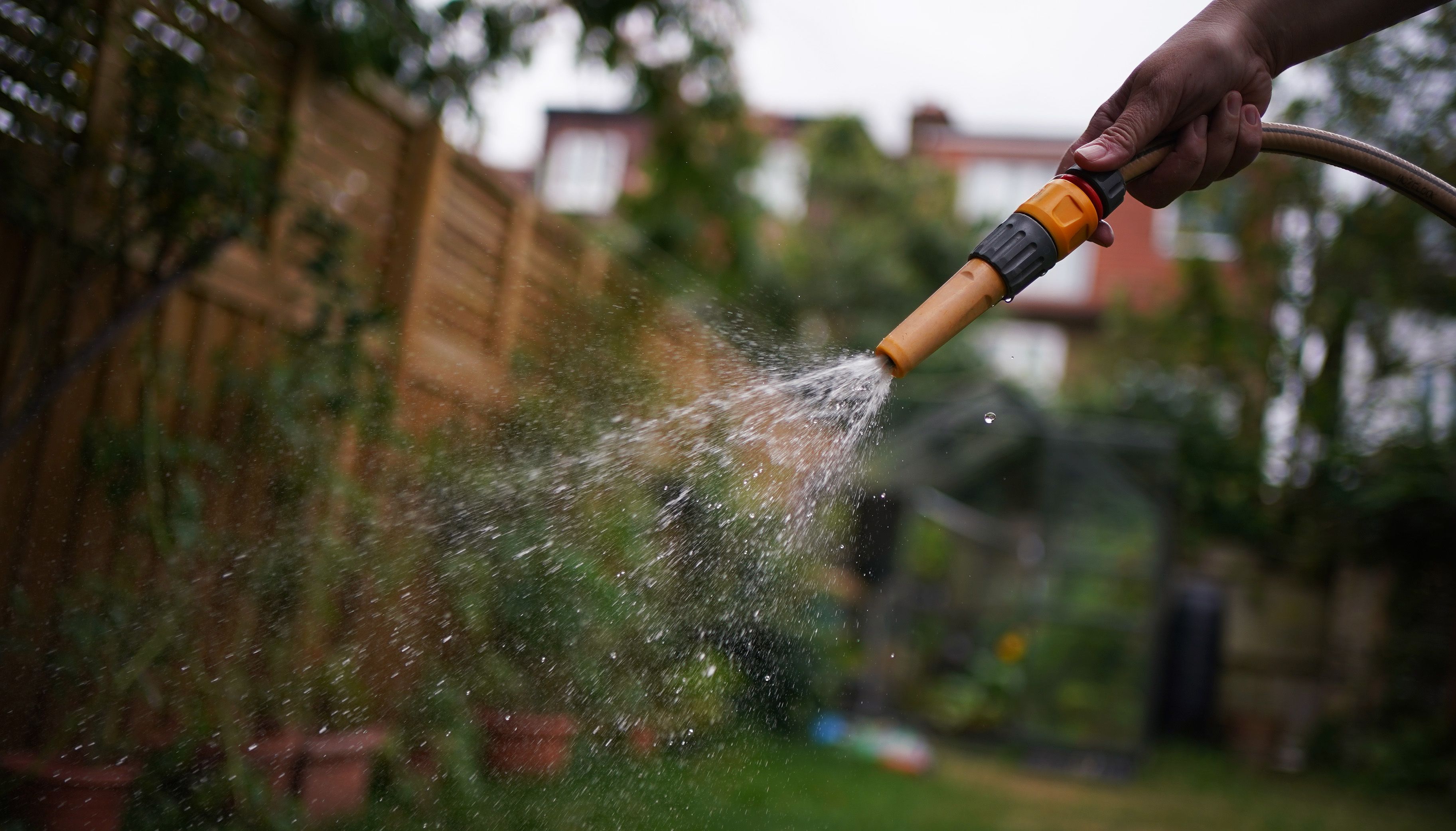 A hosepipe is used in a garden in London. South East Water, supplier for Kent and Sussex has become the latest to announce a hosepipe ban citing demand this summer breaking %22all previous records%22 amid %22extreme%22 dry conditions. Picture date: Sunday July 31, 2022.