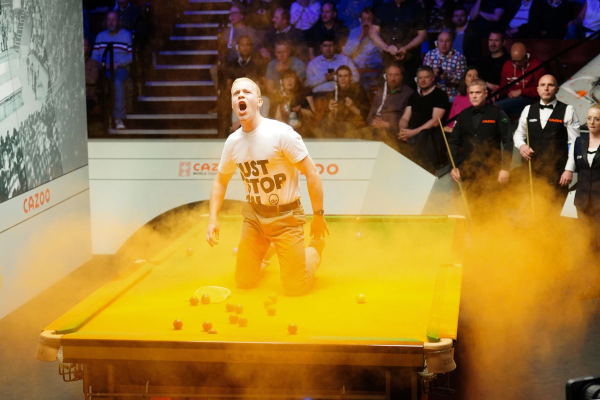 A Just Stop Oil protester jumps on the table at the World Snooker Championships