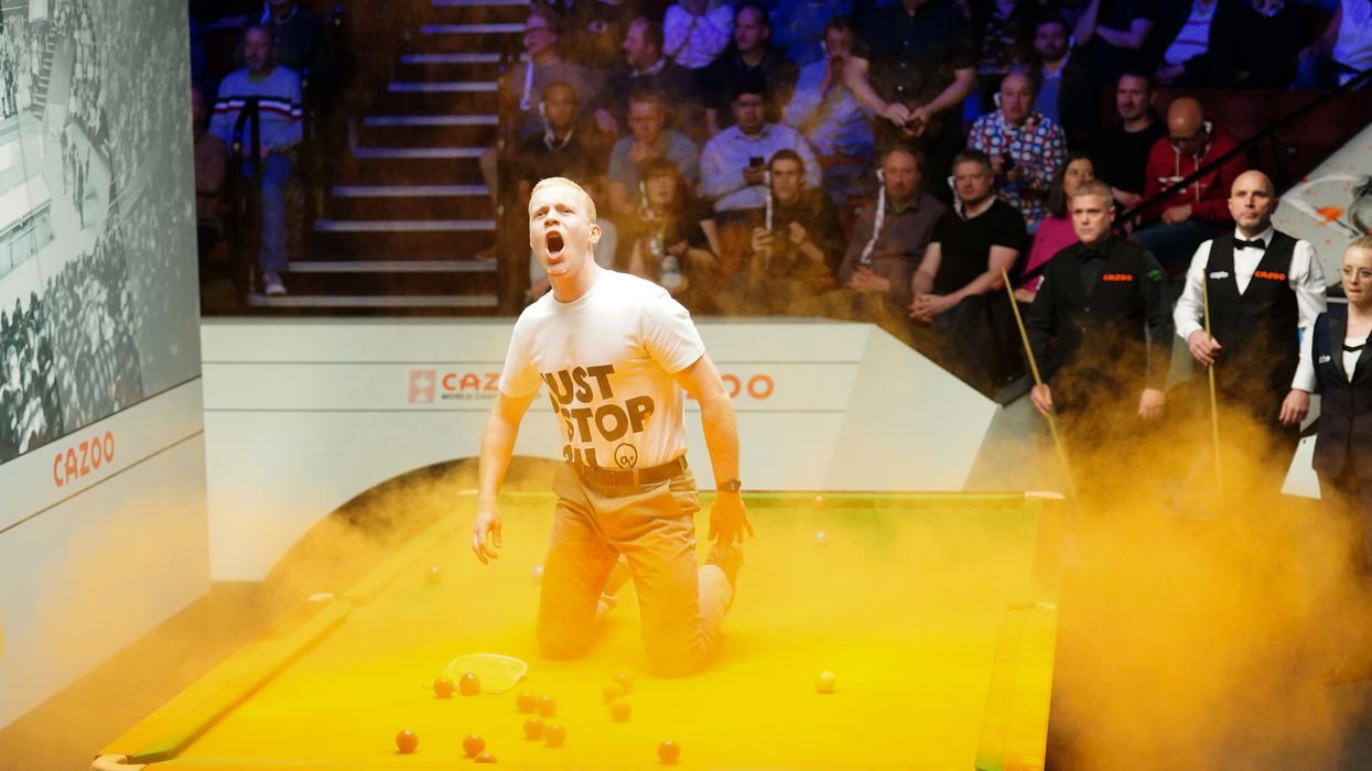 A Just Stop Oil protester jumps on the table at the World Snooker Championships
