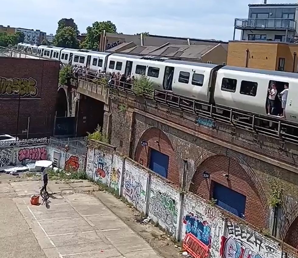 A JustEat driver hurls drinks up to the stuck train