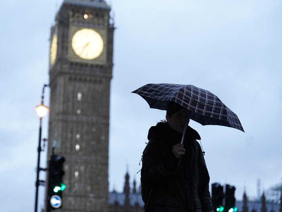 A lady walks with an umbrella near to Parliament Square in Westminster, London. Motorists are being warned to stay off the roads as cars have become stuck in flood water caused by downpours and the UK prepares to suffer %22miserable conditions%22 over the next two days. Picture date: Thursday November 17, 2022.