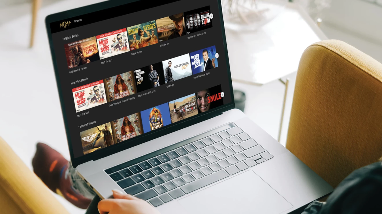 a laptop on someone's lap with the mgm plus homescreen on display with artwork of all the available shows and films